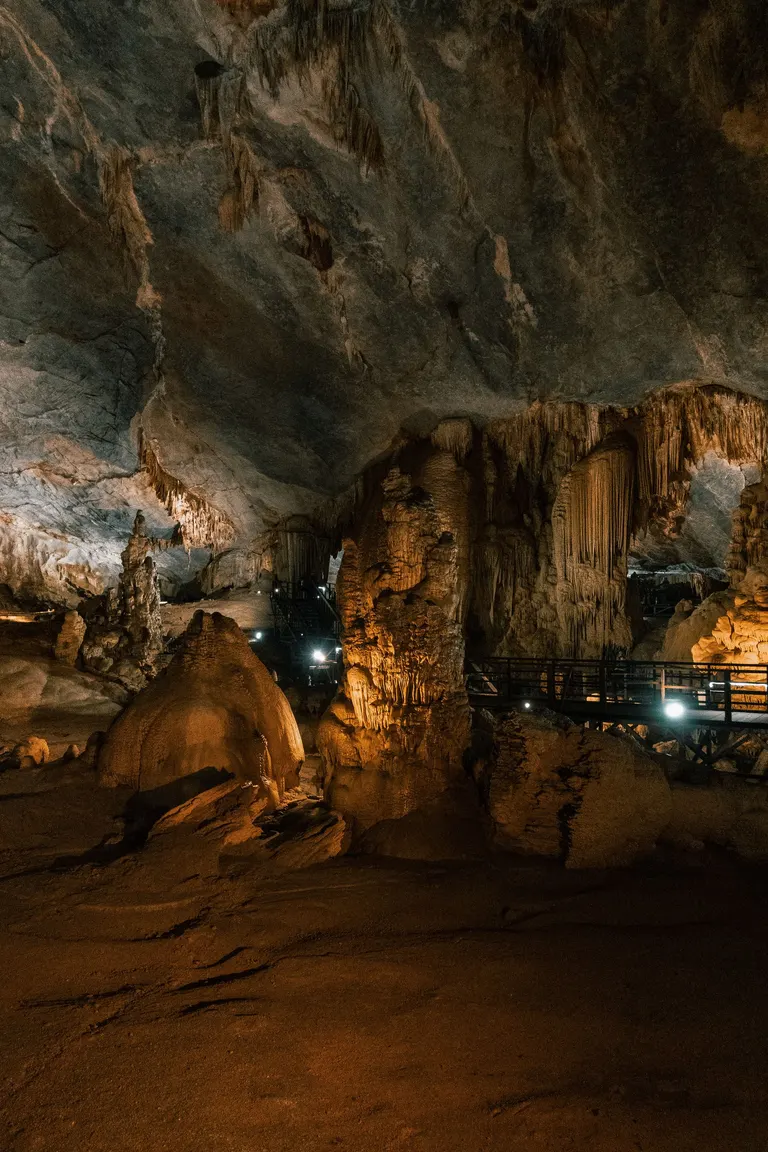 Lit stalactites and rock formations inside a cave in Phong Nha
