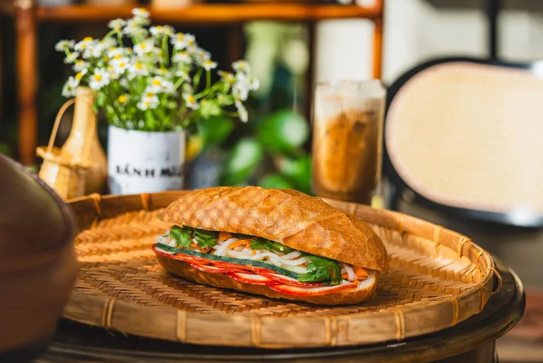 A banh mi served on a woven bamboo tray in a cosy cafe