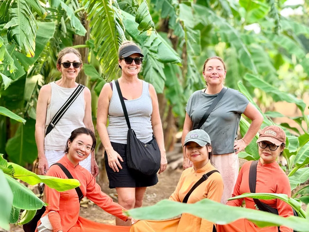 A small group of women with their local guide in a tropical garden