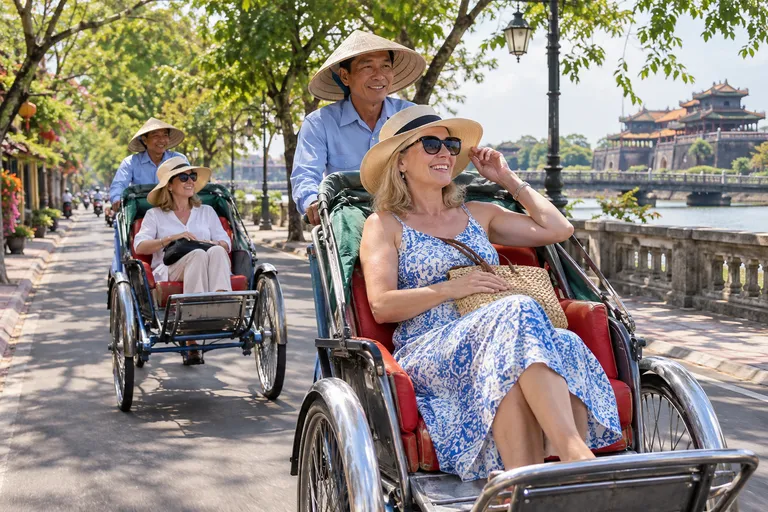 Friends on a cyclo ride along the riverside past an imperial pavilion