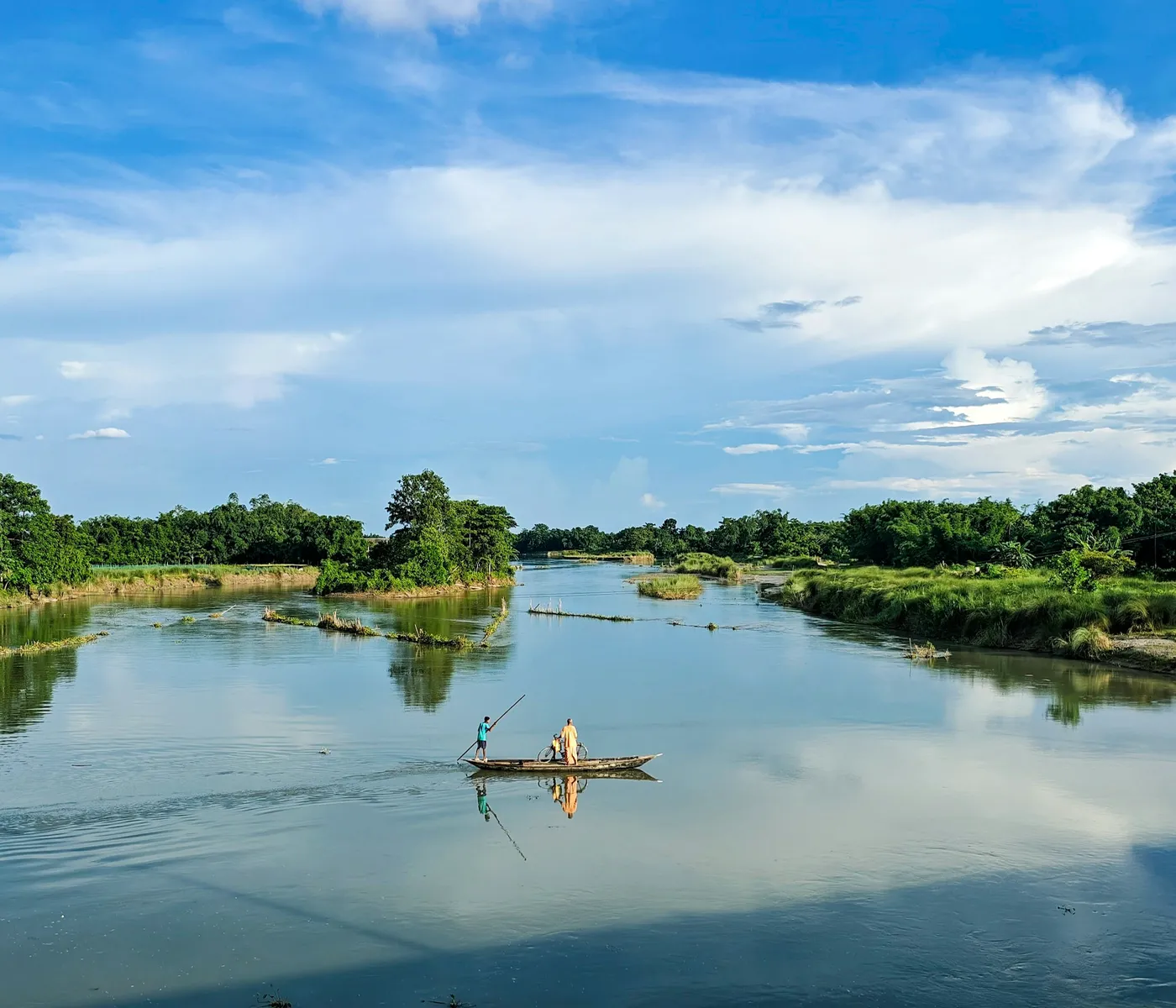 A boat drifting on the Perfume River under a wide sky