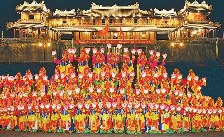 A royal court music and dance performance in front of the illuminated Hue Imperial City
