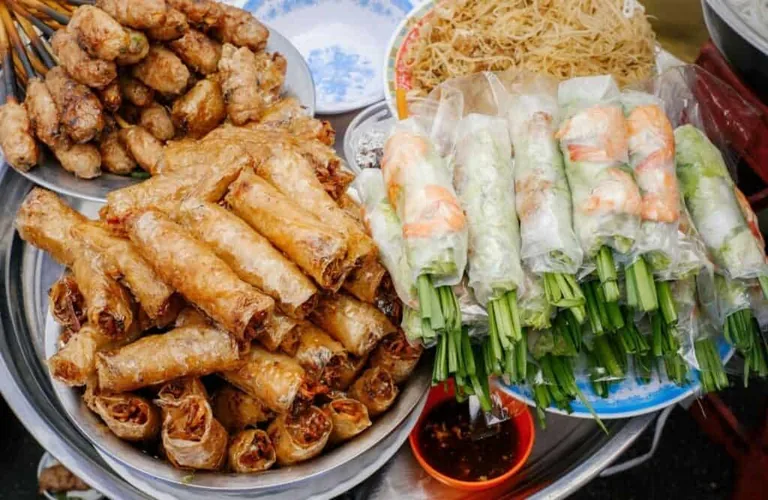 Fried and fresh spring rolls piled on a platter