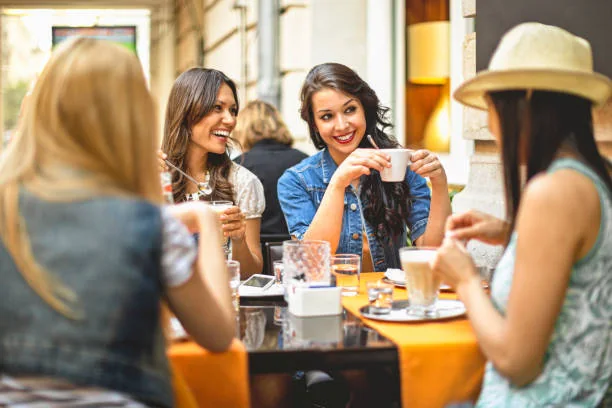 Friends chatting over coffee at a cafe table